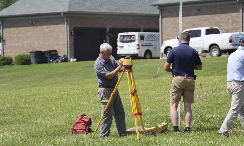 A Team Of Experts From Soils Inc In A Green Area Setting Up Their Soil Inspection Devices And Setup Around The Site