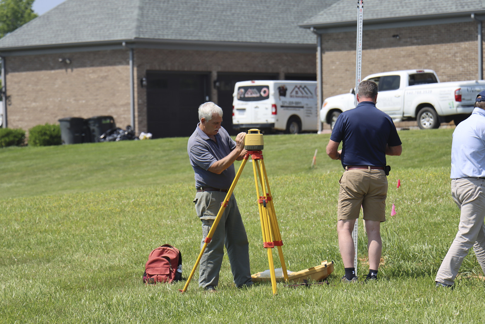 A Team Of Experts From Soils Inc In A Green Area Setting Up Their Soil Inspection Devices And Setup Around The Site