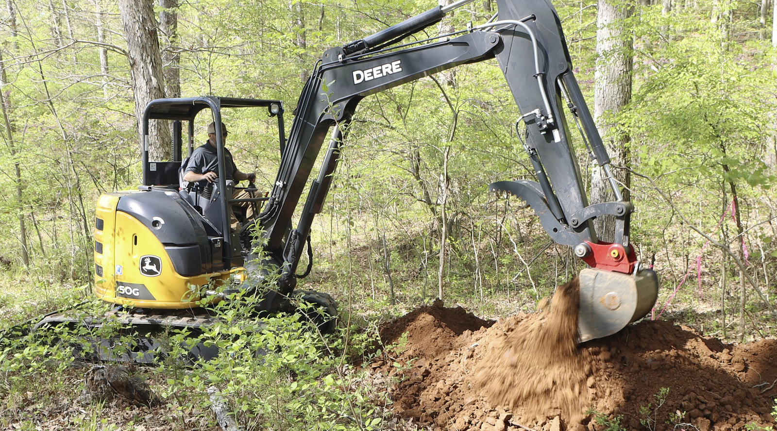 Professional Tractor Driver From Soils Inc Operating The Tractor To Pick Up Soil From A Mound
