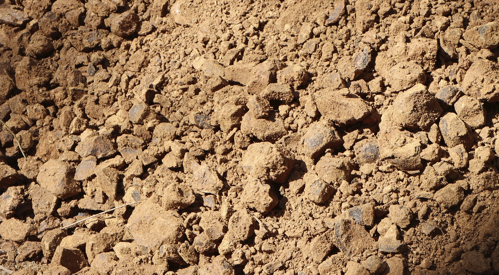 View of scattered soil and small stone pieces after being dug out from the surface of the earth by Soils Inc.